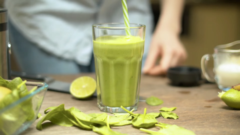 A Glass of Vibrant Green Smoothie Cleanse Sits on A Wooden Table