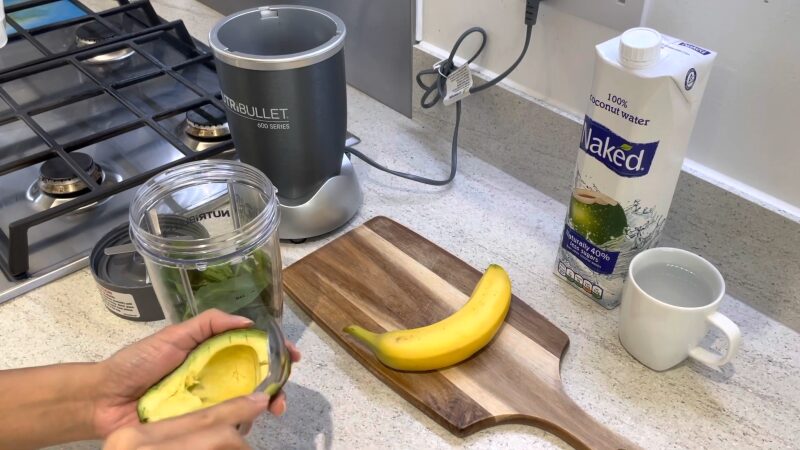 Hand Placing Chunks of Ripe Avocado Into a Blender