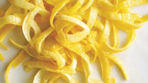 Close-up of thinly sliced yellow citron peels on a flat surface