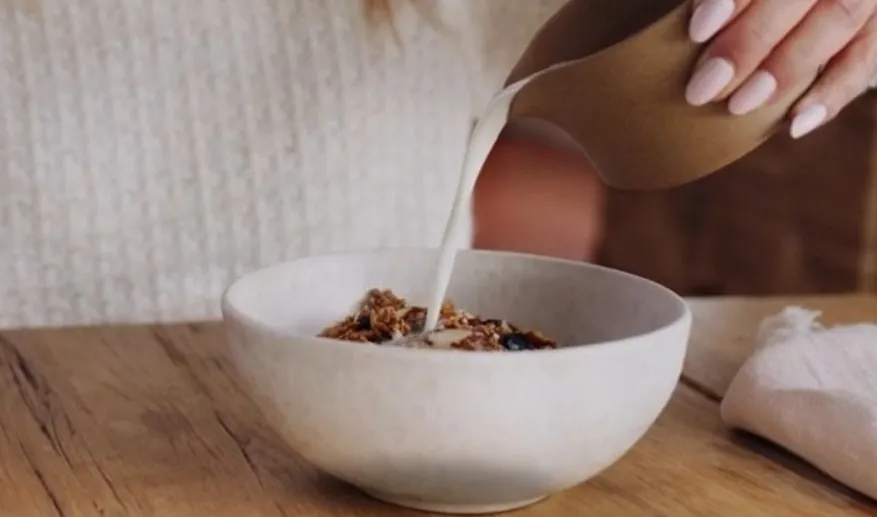 Woman pouring milk in bowl