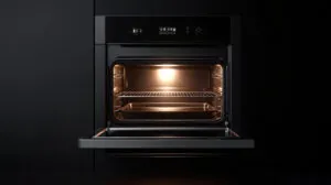 Open oven preheating with a tray inside, illuminated with a warm light