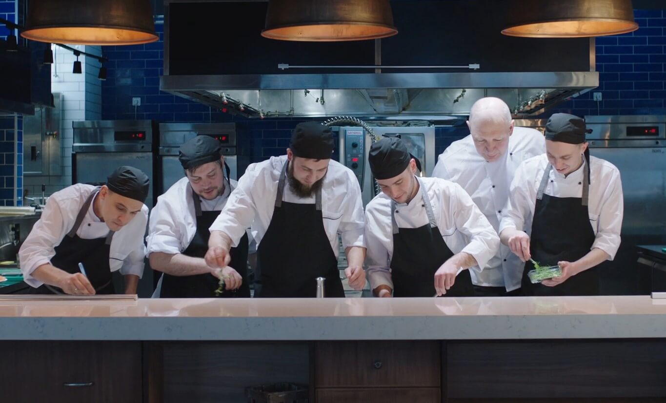 Culinary team meticulously preparing ingredients in a professional kitchen