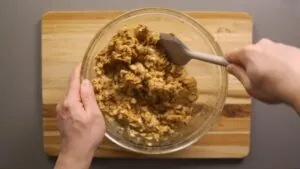 A Person Mixing Dry and Wet Ingredients with A Spatula to Form the Dough for Homemade Protein Bars