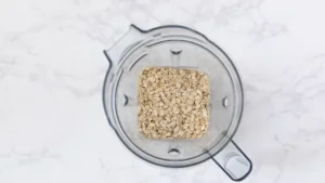 Rolled Oats in A Blender Ready to Be Ground Into Oat Flour for Homemade Protein Bars