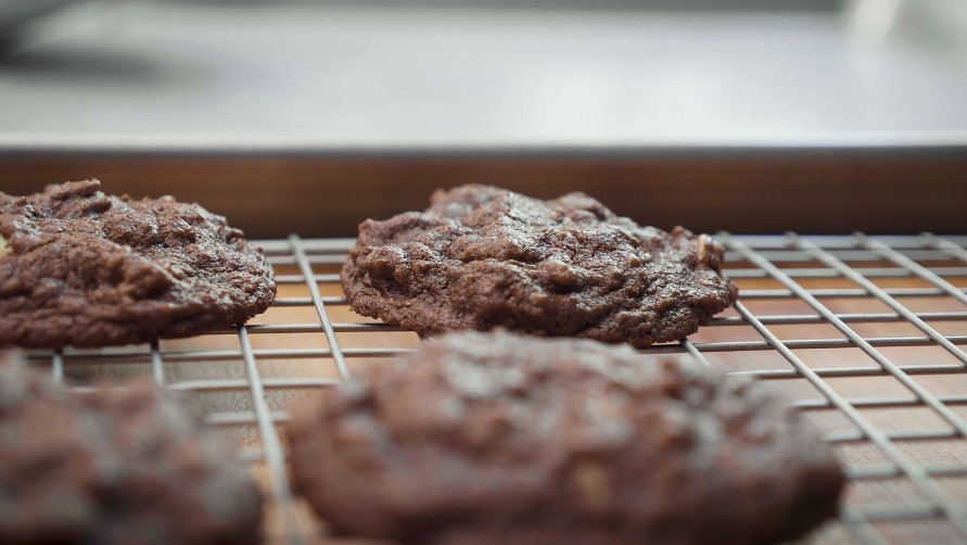 Freshly baked chocolate cookies cooling on a wire rack